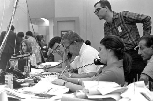 Black and white photo of CPS analysts at a news desk